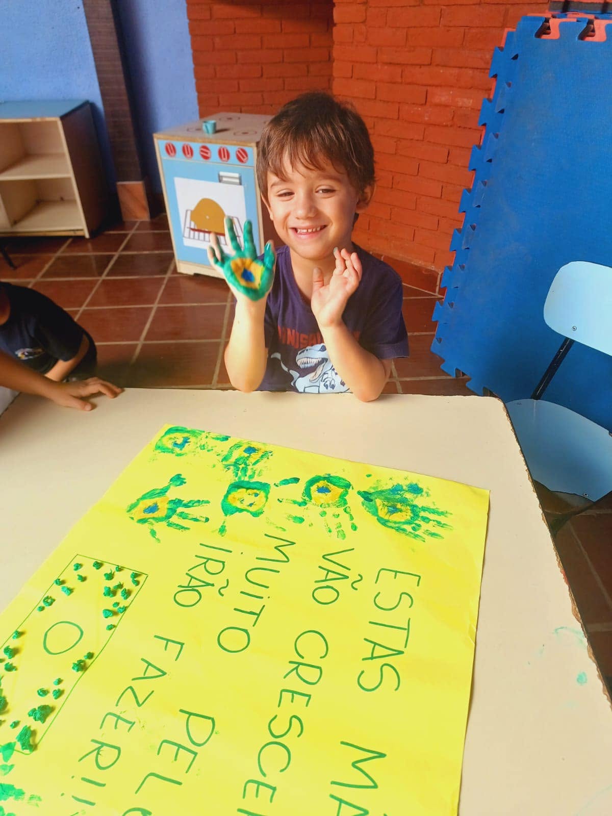 Menino sorrindo com a mão pintada
