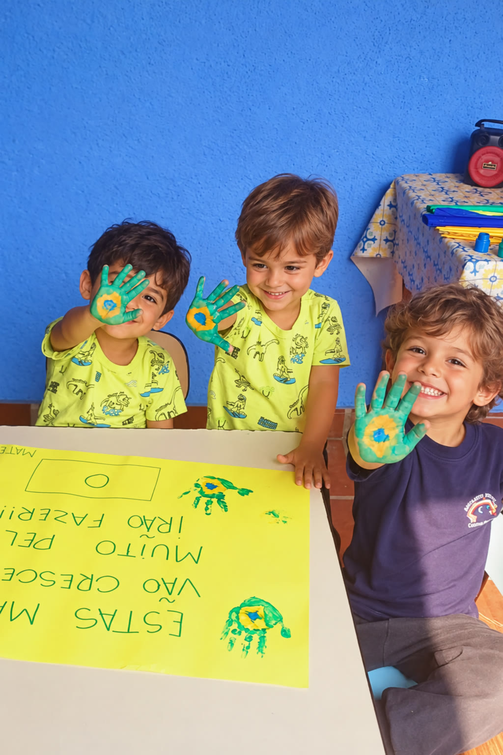 Meninos mostrando as mãos pintadas de verde e amarelo